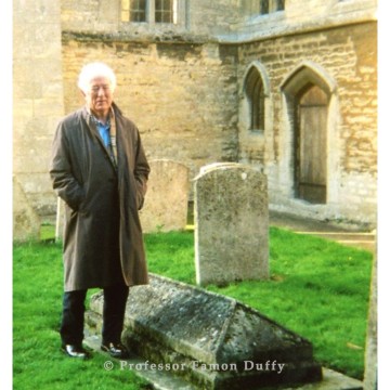 Seamus Heaney standing in a churchyard by the grave of John Clare.